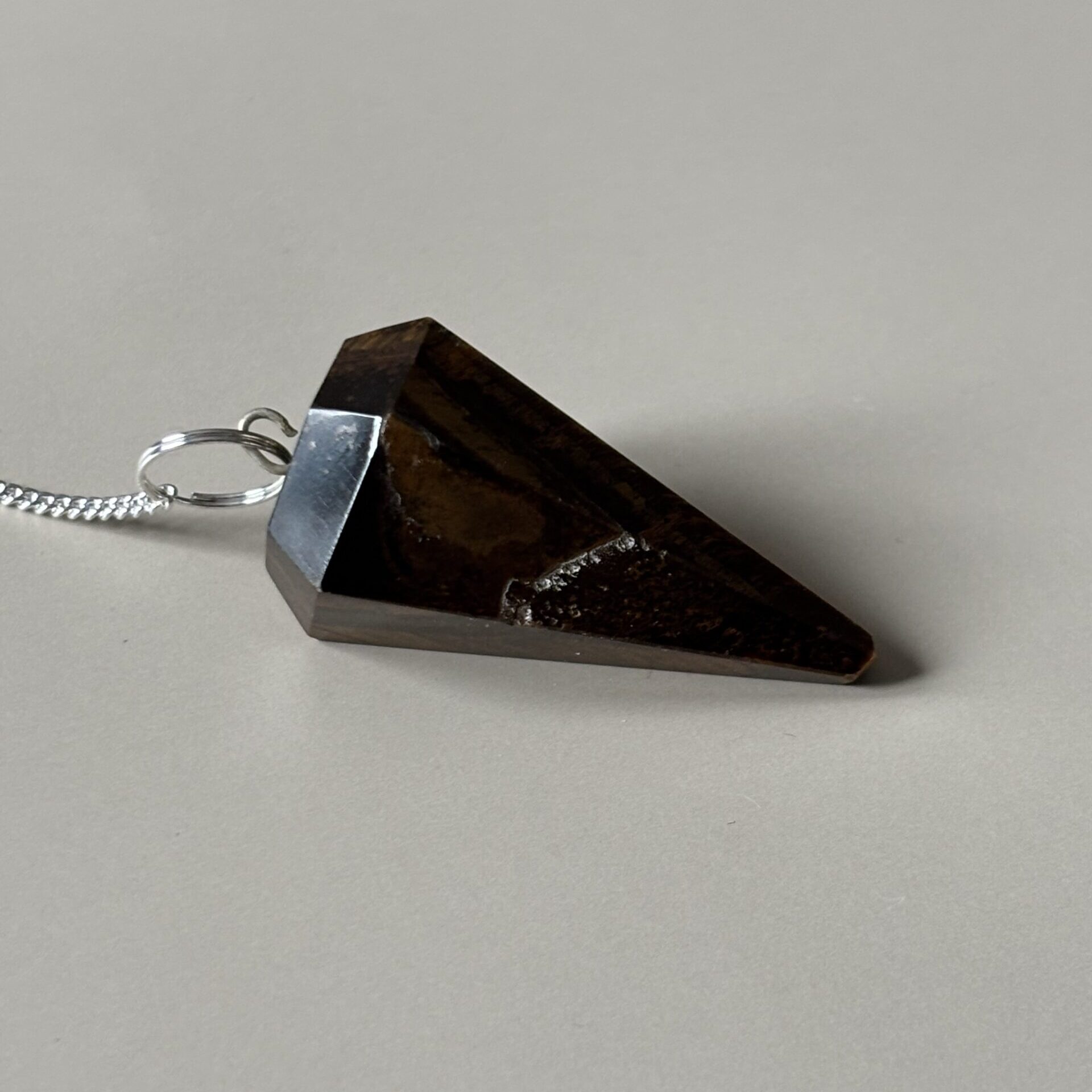 Pendule artisanal en œil de tigre facetté, outil de radiesthésie et ancrage spirituel