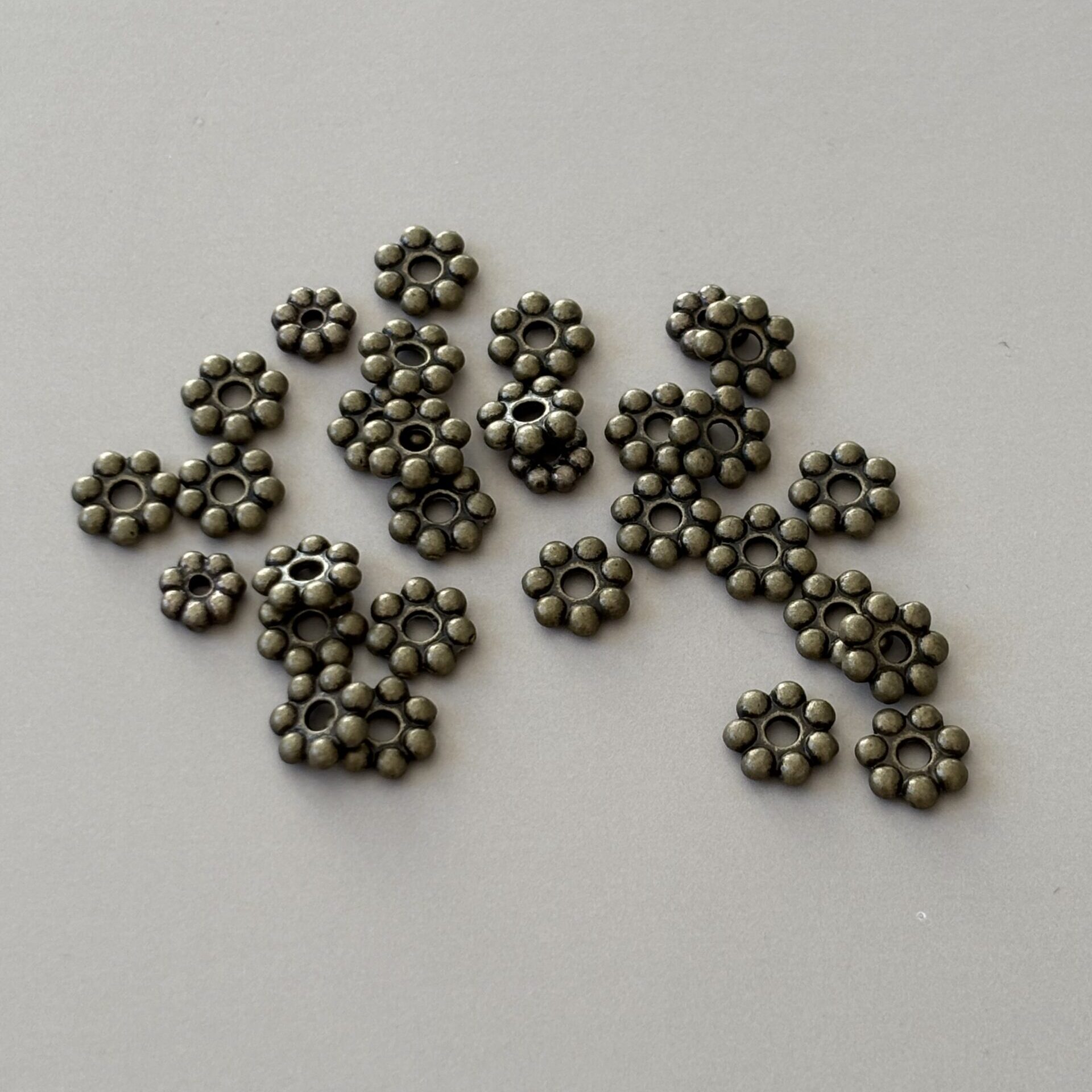 séparateur fleur métal bronze – symbole d’ancrage, d’énergie terrestre et de force créative